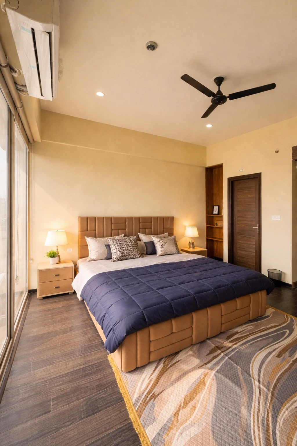 King bed with quilted headboard and wooden flooring