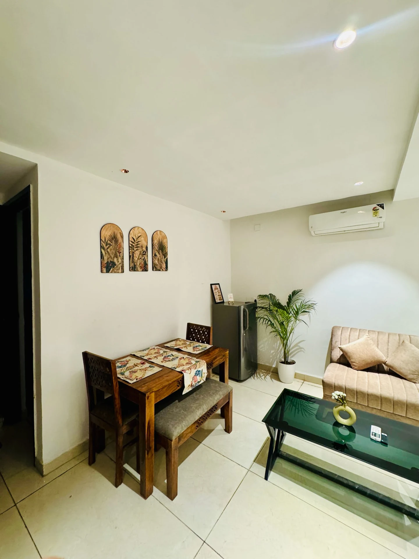 Living and dining area with sofa, AC and refrigerator