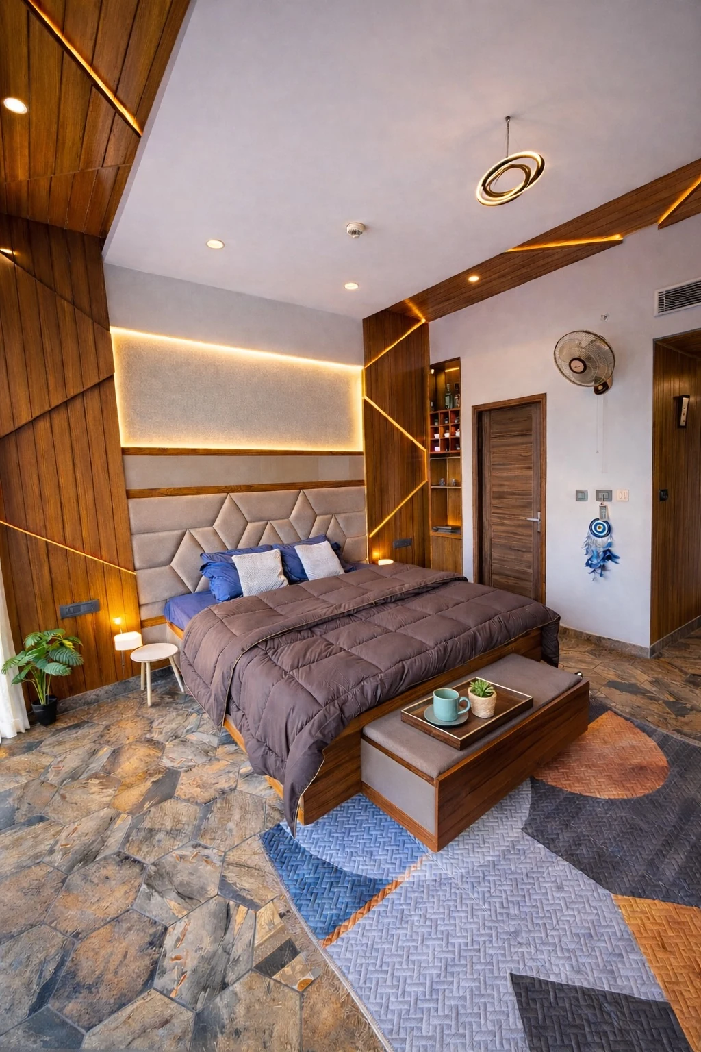 Bedroom with warm cove lighting and stone flooring